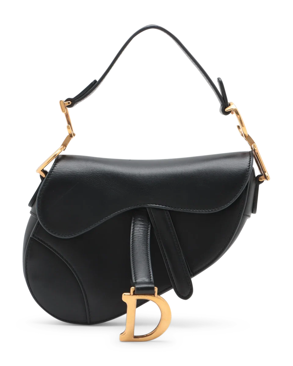 Classic black Dior Saddle Bag featuring structured shape, antique gold hardware, and shoulder strap